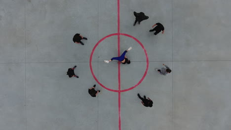 Young-male-breakdancer-dancing-with-his-friends-around-in-circle.-Drone-vertical